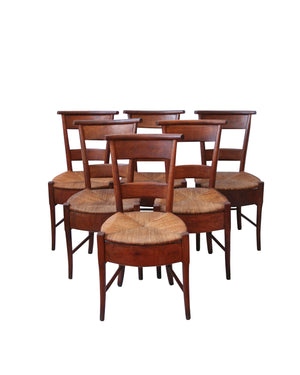 Conjunto de seis sillas francesas en madera de nogal con faldón y asiento de enea. Época directorio