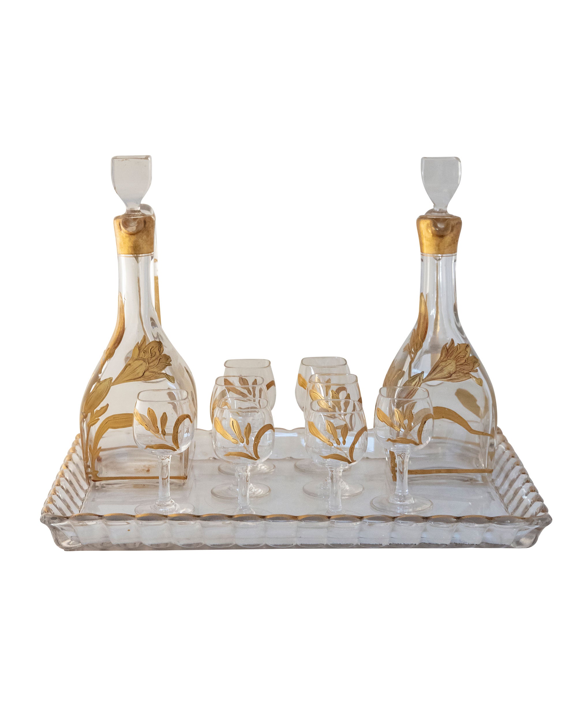 Set de ocho vasos y dos botellas de licor de cristal y pintura dorada con motivos florales con bandeja