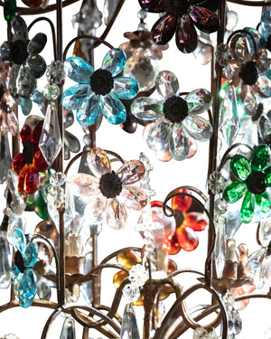 Lámpara de araña con estructura dorada y flores de cristal en varios colores