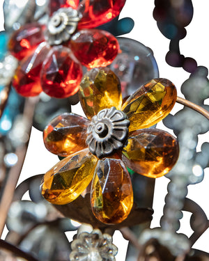Lámpara de araña con estructura dorada y flores de cristal en varios colores