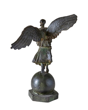 Bronze sculpture patinated in green of a winged goddess standing on a ball