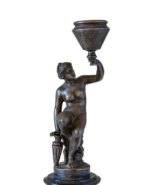 Pair of bronze candle-holders supported by naked women on a wooden pedestal